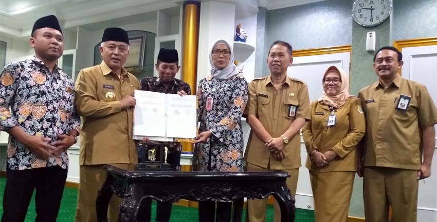 Ketua KPU Kabupaten Malang Anis Suhartini (Kanan berjilbab) bersama Bupati Malang HM Sanusi, menunjukkan hasil penandatanganan NPHD. (Ist)