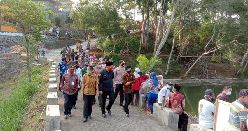 Kepala Desa Gedangan Hendik Krisdianto Saat Dampingi Bupati Malang Dalam Proses Penebaran Bibit Ikan. (ist)