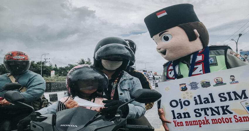 Maskot Satlantas Polres Malang ingatkan pengendara untuk taat berlalu lintas.